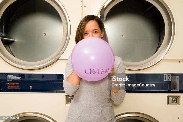 Young Women Blowing Up A Balloon At The Laundromat Stock Photo - Download Image Now