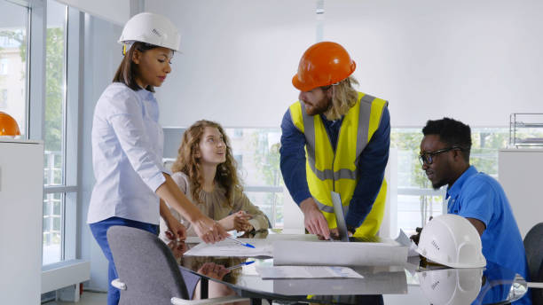 istock Diverse team of engineers and architects discussing construction and drawing construction plans 1490608415