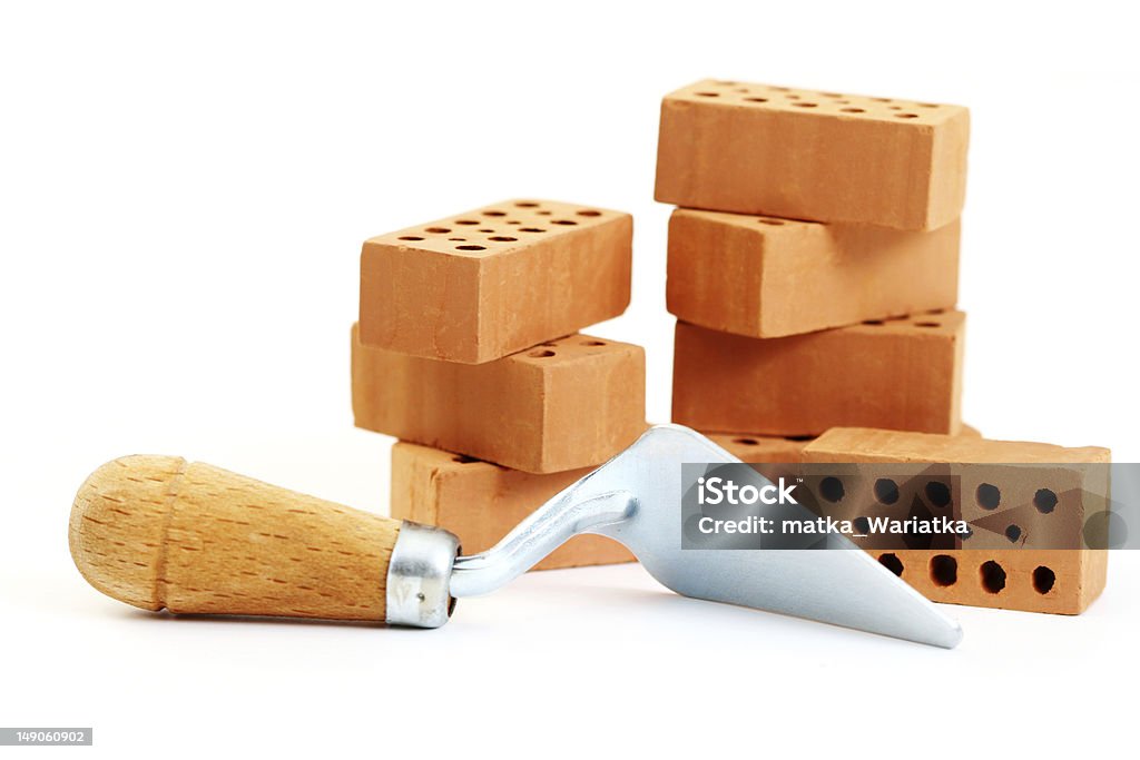 A shovel tool and several stacked bricks stack of bricks on white Construction Material Stock Photo