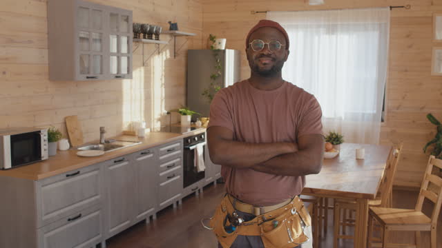 Confident Handyman Standing In Kitchen