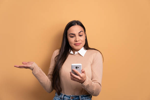 istock puzzled woman with sad face expression in beige colors. 1490612293