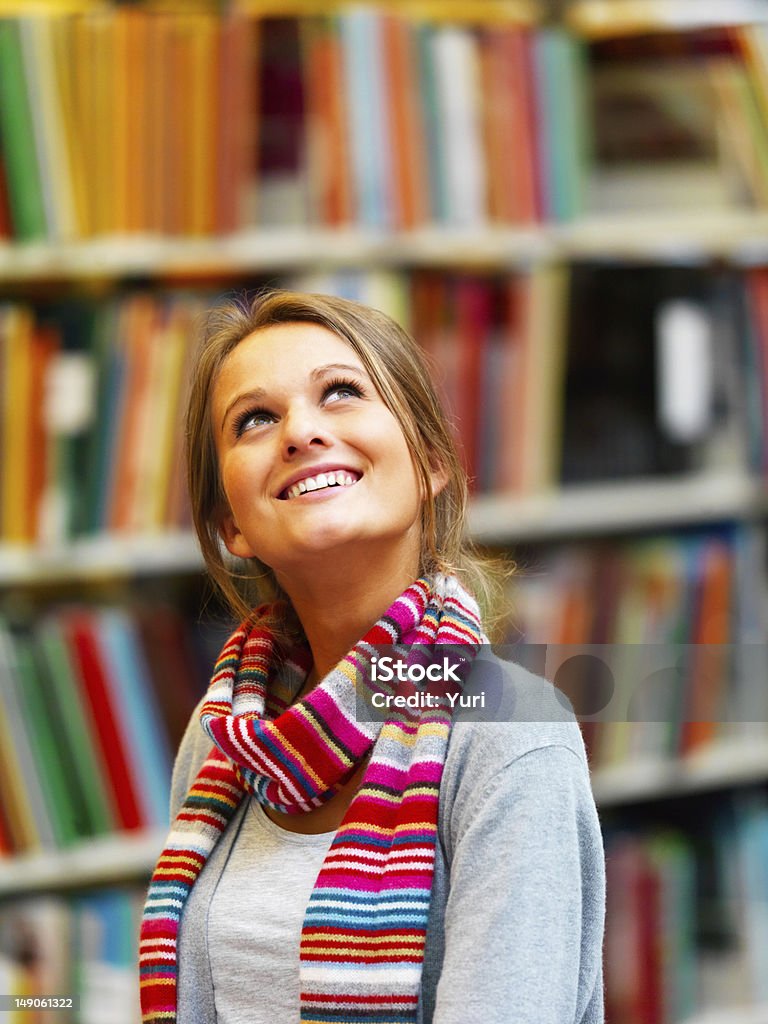 Bela jovem em pé na biblioteca - Foto de stock de Biblioteca royalty-free