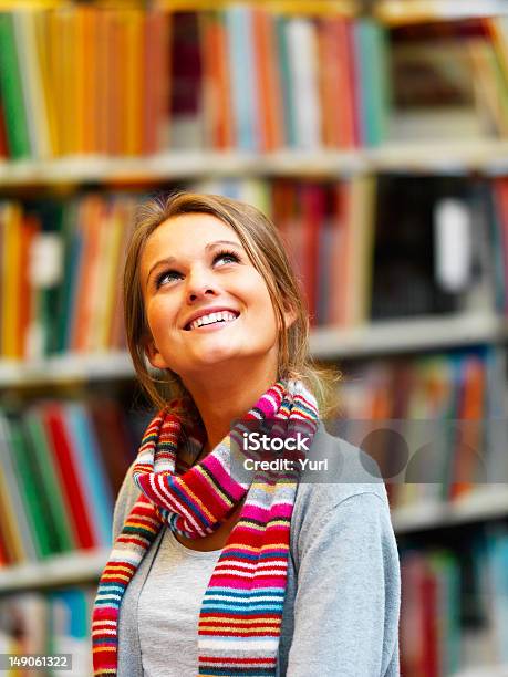 Foto de Bela Jovem Em Pé Na Biblioteca e mais fotos de stock de Biblioteca - Biblioteca, Cultura Jovem, Livro