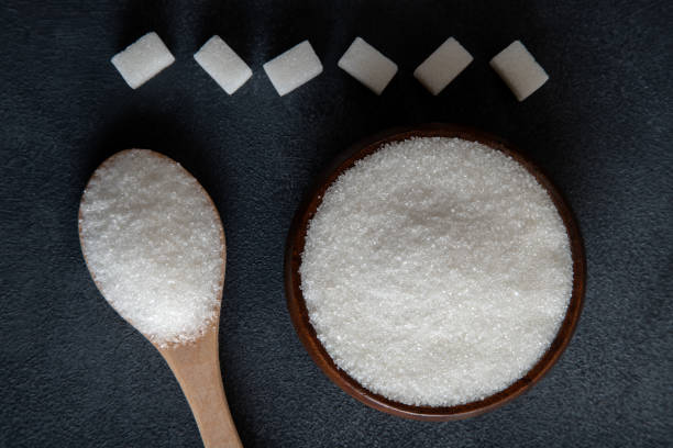 istock Cube sugar and granulated sugar on black background 1490613432