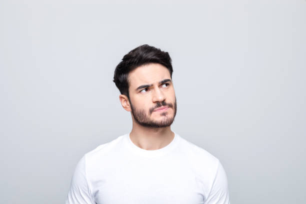 istock Headshot of thoughtful young man peeking at copy space 1490615409
