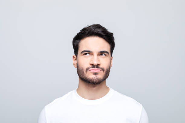istock Headshot of thoughtful young man peeking at copy space 1490615442