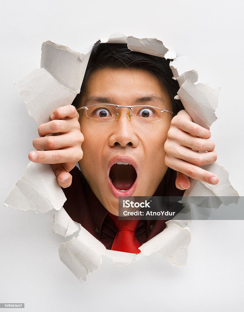 Hombre contempla sorprendentemente de orificio en pared - Foto de stock de 20 a 29 años libre de derechos