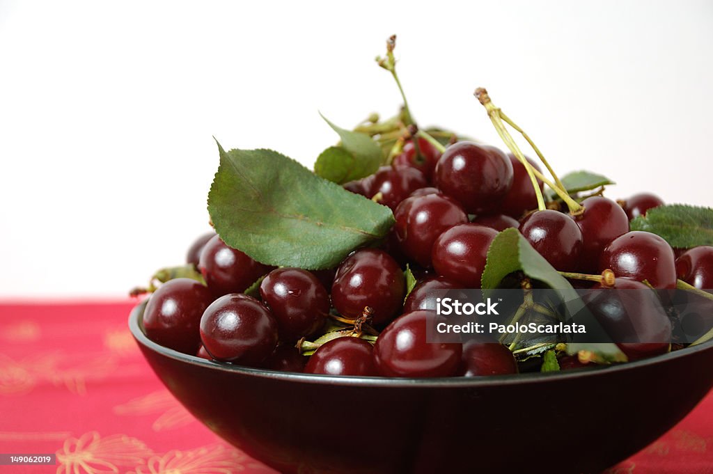 Heaping Bowl of Cherries Bowl of freshly picked ripe and juicy cherries of the tart Balaton variety with leaves. Life's a Bowl of Cherries Stock Photo