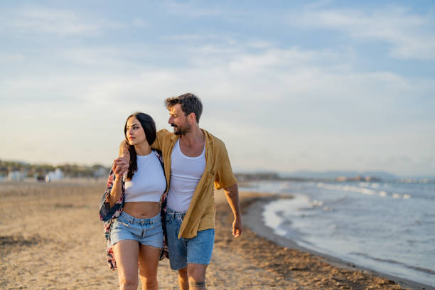 istock Young couple enjoying a stroll on the beach 1490620562