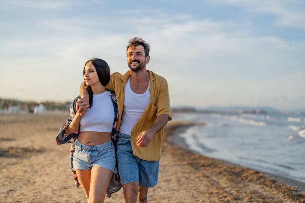 istock Happy young couple walking on the beach 1490620616