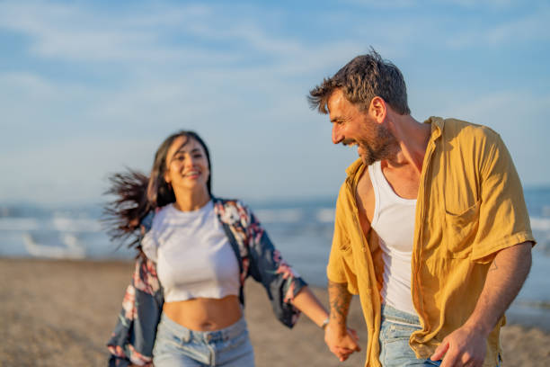 istock Couple Walking Holding Hands on Beach at Sunset 1490620674