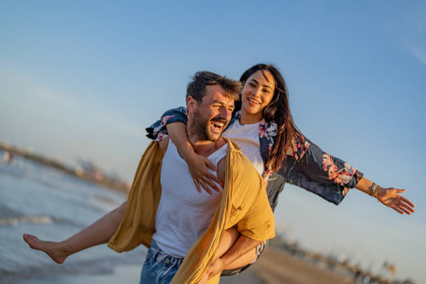 istock Young man carrying his girlfriend on his back at the beach. 1490621285