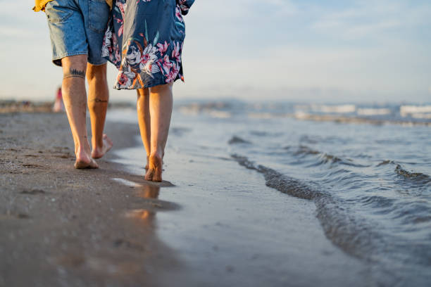 istock Low section of a couple walking on the beach 1490621481