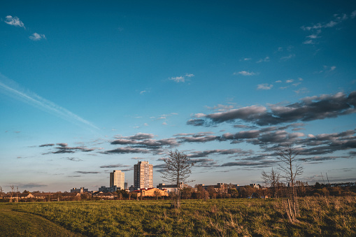 A view from the park on the council blocks of flats far away on the horizon against a blue sky in North London.