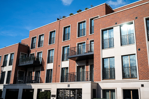 A modern red brick apartment building on a sunny day in central London.