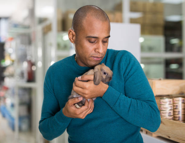 Man holding cute rabbit in pet shop