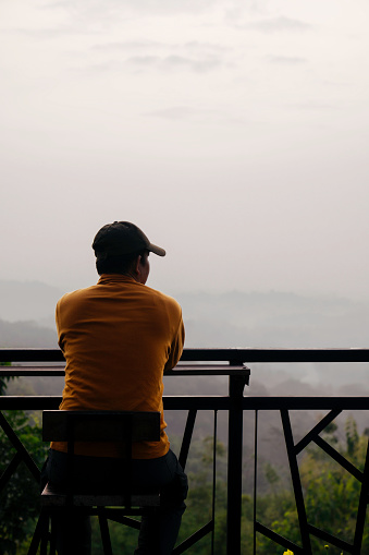 asian man looking at view of bukit situmbu (Punthuk Setumbu) magelang