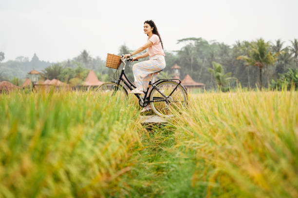 마을에서 자전거로 즐거운 시간 보내세요 - bali indonesia rice paddy rice 뉴스 사진 이미지