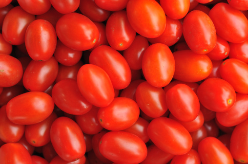 A close up shot of a pile of grape tomatos