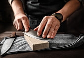 Man sharpening a knife with whetstone