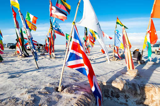 Salar de Uyuni, Bolivia - 21 October 2018: Sunshine bright flags from different countries