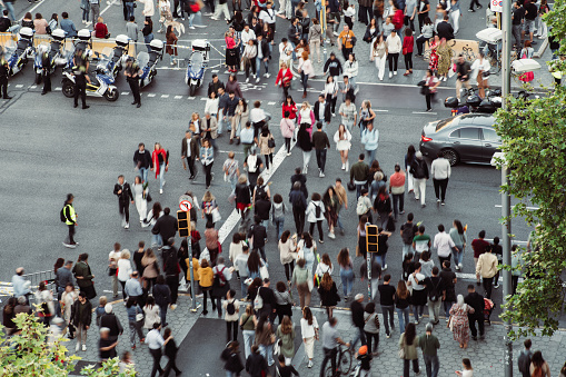 Crowd of people walking at zebra crossing.