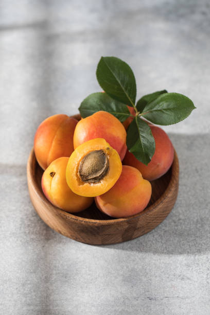 istock Ripe juicy apricots on a plate on a grey background with shadow. Fresh fruit . 1490631063