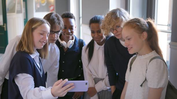 istock Diverse teen classmates communicate and use smartphone in the school corridor 1490633908