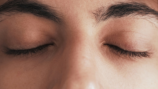 Closed eyes. Mind relaxation. Spiritual meditation. Mindfulness serenity. Closeup of peaceful tranquil calm male face with dark eyelashes eyebrows.