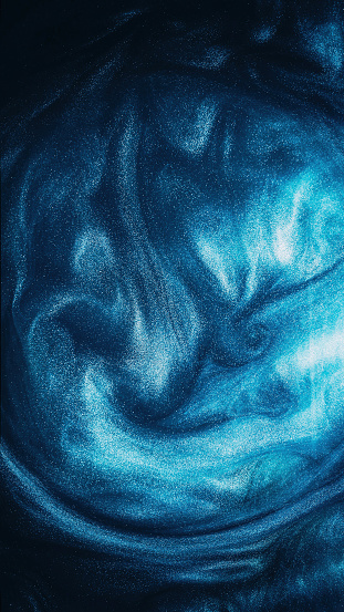 Sparkling fluid. Ink water. Storm wave. Blue color glowing shimmering glitter texture vapor cloud on dark black abstract background.