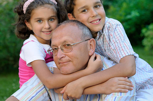 Grandfather and kids outdoors stock photo
