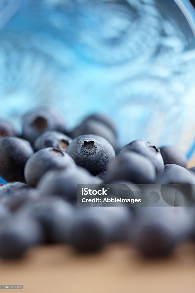 Blueberries Fresh blueberries spilling out of a blue crystal bowl, with selective focus. Antioxidant Stock Photo