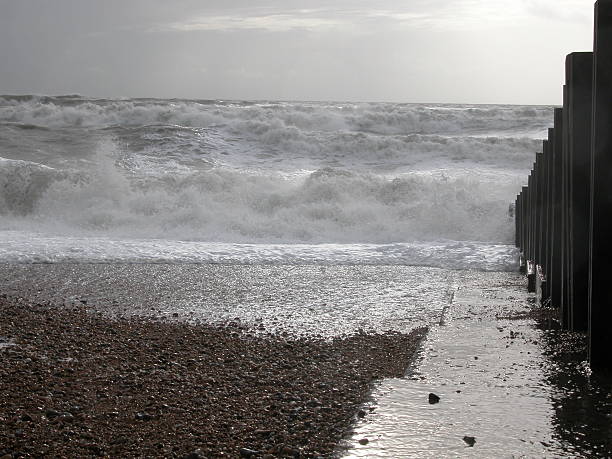 Rollers on shore by the groin stock photo