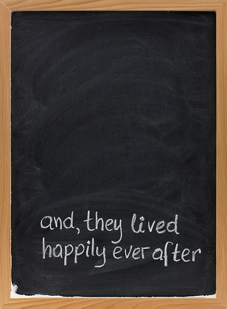 fairytale happy end phrase on blackboard and, they lived happily ever after -  stock phrase for ending oral narratives or fairytale handwritten with white chalk on blackboard, copy space above happy end stock pictures, royalty-free photos & images