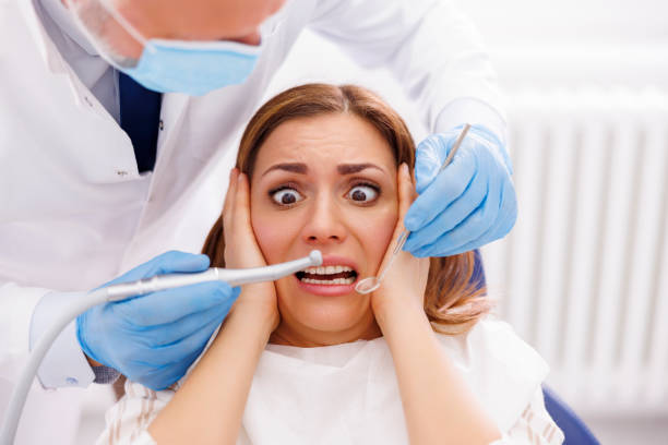 istock Woman scared while doctor is fixing her tooth at dentist office 1490640527
