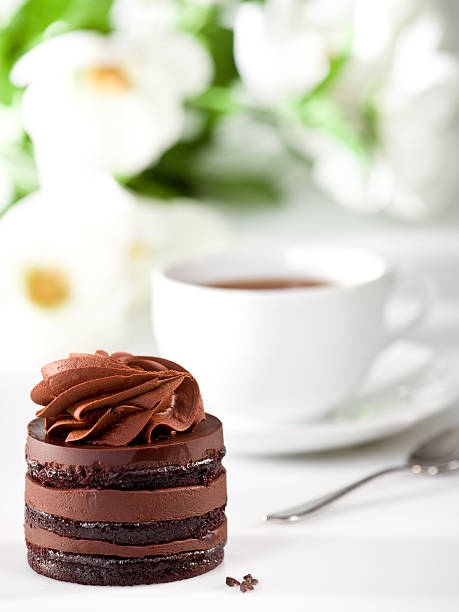 Chocolate cake, tea and flowers stock photo