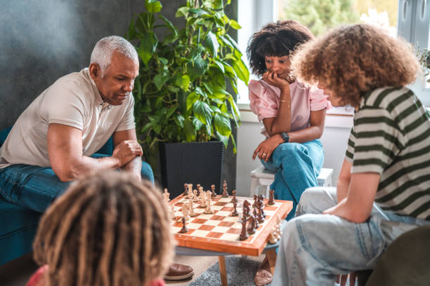 ajedrez: una emocionante tradición familiar en un hogar acogedor - chess skill concentration intelligence fotografías e imágenes de stock