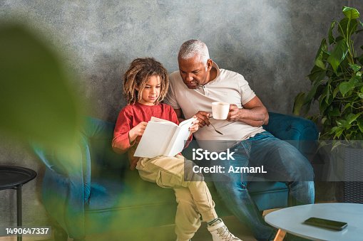istock Cozy Father-Son Time: Engaged in a Shared Reading Experience 1490647337