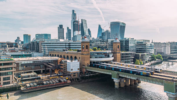 personenzüge, die die eisenbahnbrücke cannon street überqueren, überqueren die themse mit der skyline von london, england im hintergrund - fenchurch street stock-fotos und bilder