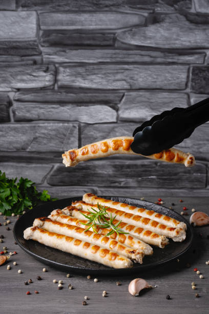 Fresh fried chicken sausages in a plate on a gray table. Empty copy space