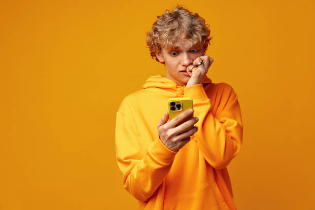 istock Happy caucasian young man using smartphone against yellow background 1490652275