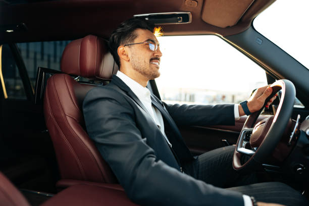 istock Young businessman in elegant suit driving luxury car 1490652349