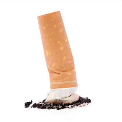 Stubbed out cigarette against a white background, representing quitting smoking