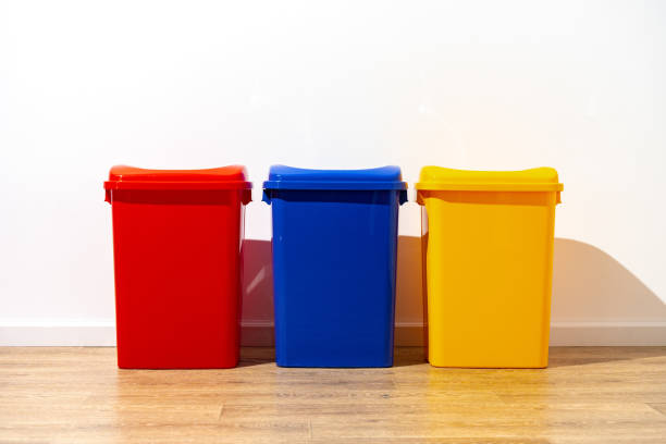 istock Three plastic trash bins against the wall in the building 1490652421