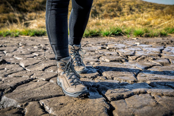 금이 간 늪에서 하이킹 부츠를 신고 있는 여자 다리 - mud shoe boot wet 뉴스 사진 이미지