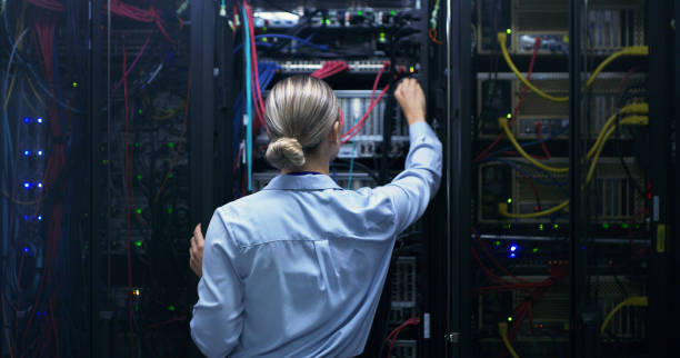 istock Woman, server room and night with cable inspection, connectivity check or maintenance for IT job. Female engineer, fiber connection or information technology for cybersecurity, storage or data center 1490656870
