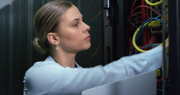 istock Woman, server room and night with cable inspection, connectivity check or maintenance for IT job. Female engineer, fiber connection or information technology for cybersecurity, storage or data center 1490657377