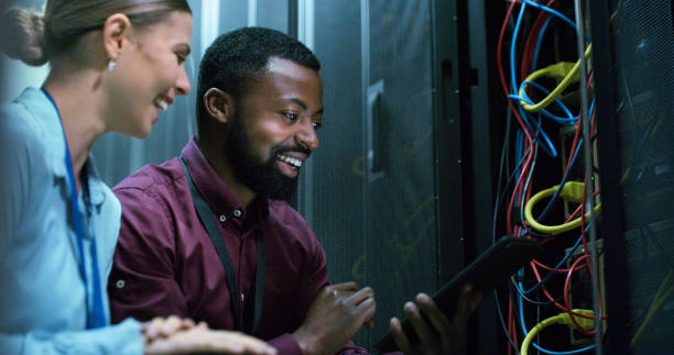 Team, man and woman technician check server room for cloud computing or cyber security at night. Tech, it engineer and people working on database for maintenance or networking in data center el equipo, el técnico hombre y la mujer revisan la sala de servidores para la computación en la nube o la seguridad cibernética por la noche. técnico, ingeniero de ti y personas que trabajan en bases de datos para mantenimiento o redes en el centro de