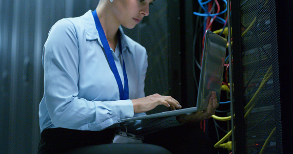 Laptop, woman and technician check server room for cloud computing or cyber security. Tech, it engineer and person working on database for maintenance or networking in data center on computer