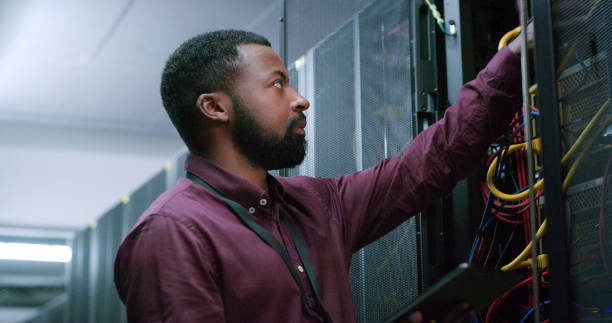istock Man, server room and night with cable inspection, connectivity check or maintenance for IT job. Male engineer, fiber connection or information technology for cybersecurity, storage or data center 1490657726